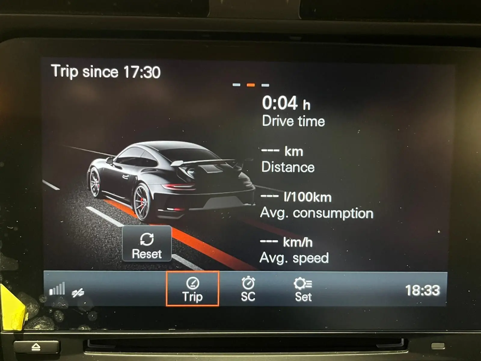 Affichage numérique montrant une Porsche 911 GT3 vue de l'arrière en gris foncé sur l'écran de bord.