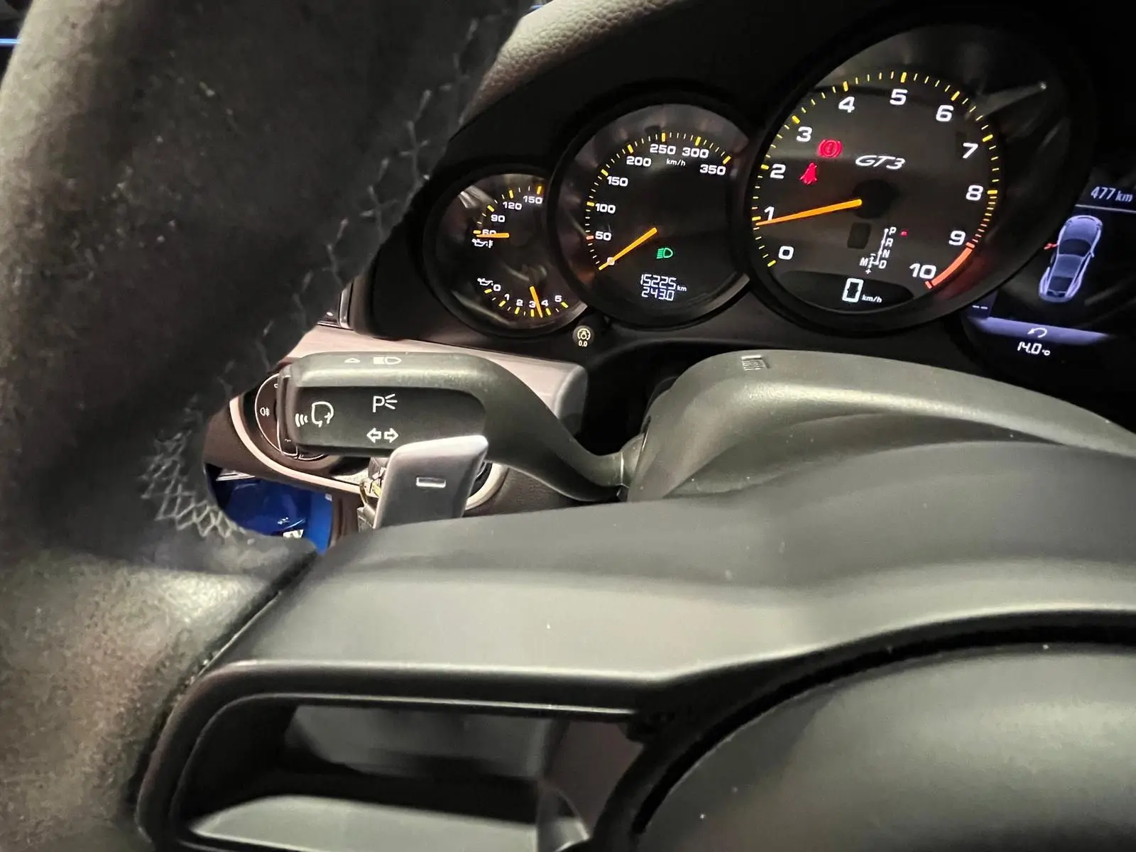 Vue rapprochée du tableau de bord de la Porsche 911 GT3 2018, affichant le compteur et le volant sport en alcantara.