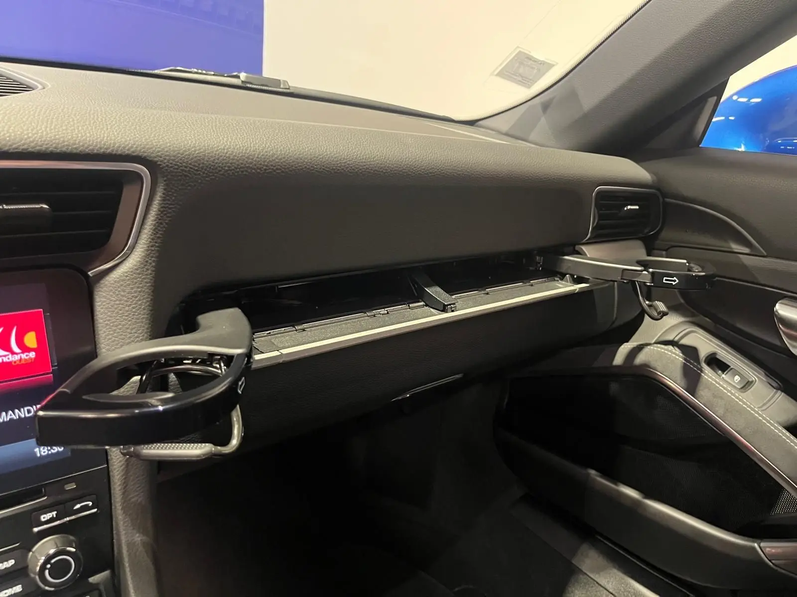 Vue intérieure du tableau de bord côté passager de la Porsche 911 GT3 avec porte-gobelets déployés et finition noire.