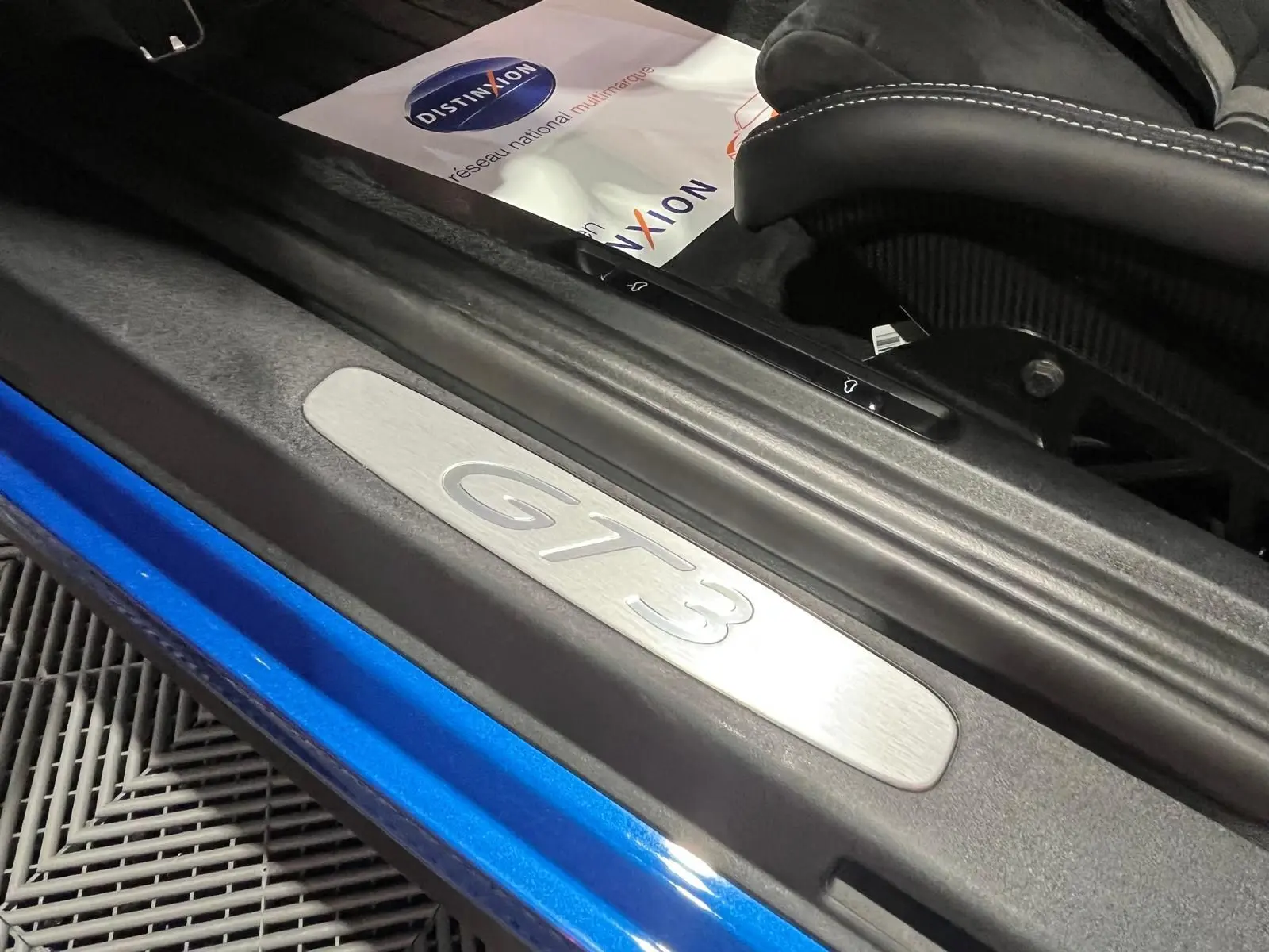 Seuil de porte GT3 en aluminium sur Porsche 911 GT3 bleu saphir, avec siège baquet carbone visible.