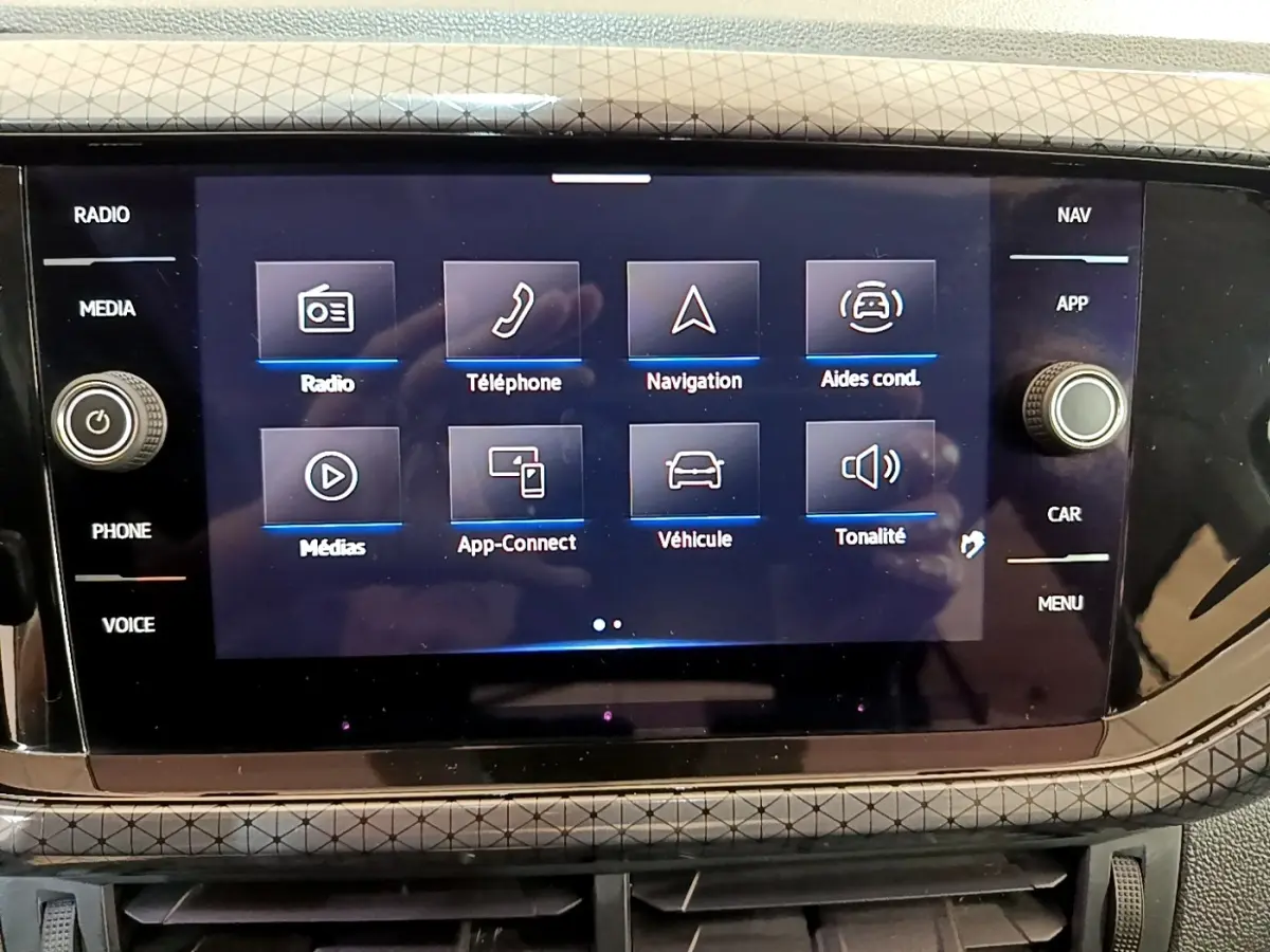 Écran tactile central du Volkswagen T-Cross noir 2022 affichant le menu principal avec navigation et aides à la conduite.