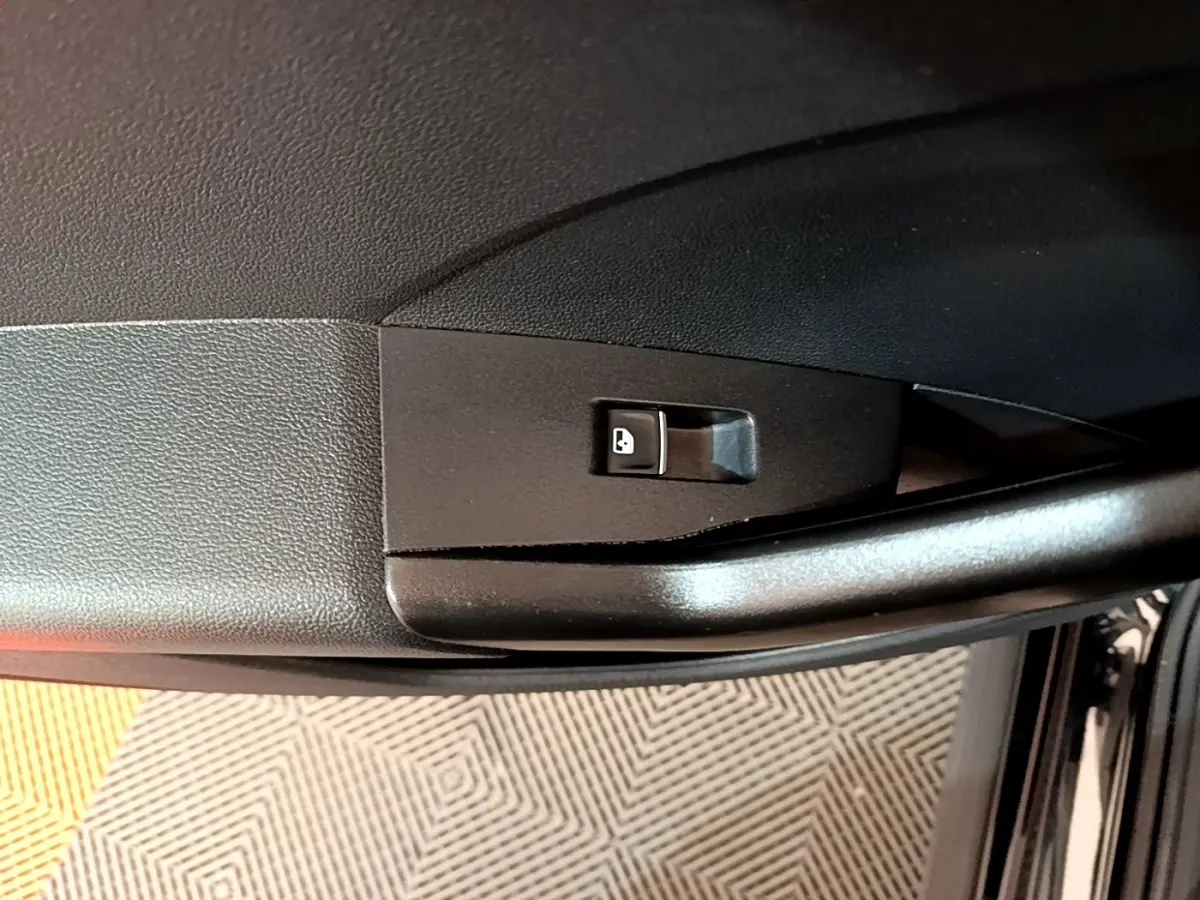 Détail de la commande de verrouillage des portes sur la portière côté conducteur d’un Volkswagen T-Cross noir 2022.