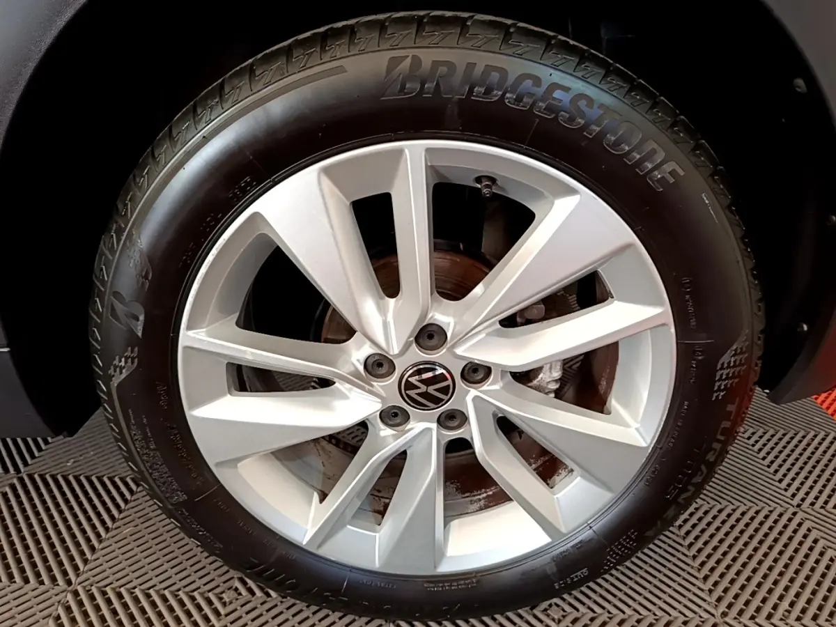 Gros plan sur la jante alliage argentée et pneu Bridgestone du Volkswagen T-Cross noir, côté roue avant.