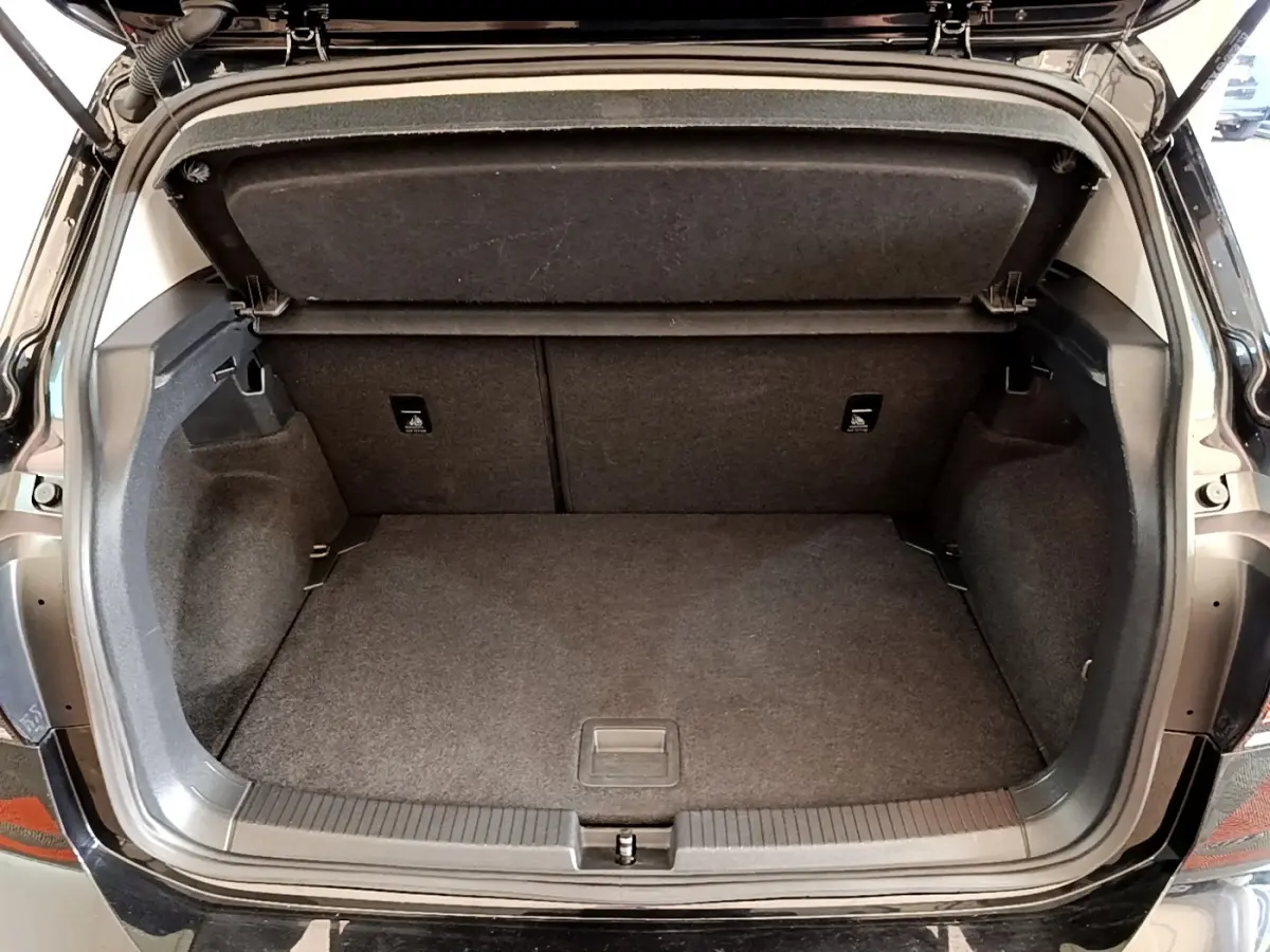 Coffre ouvert vue arrière d’un Volkswagen T-Cross noir, espace de rangement propre et spacieux sans chargement.