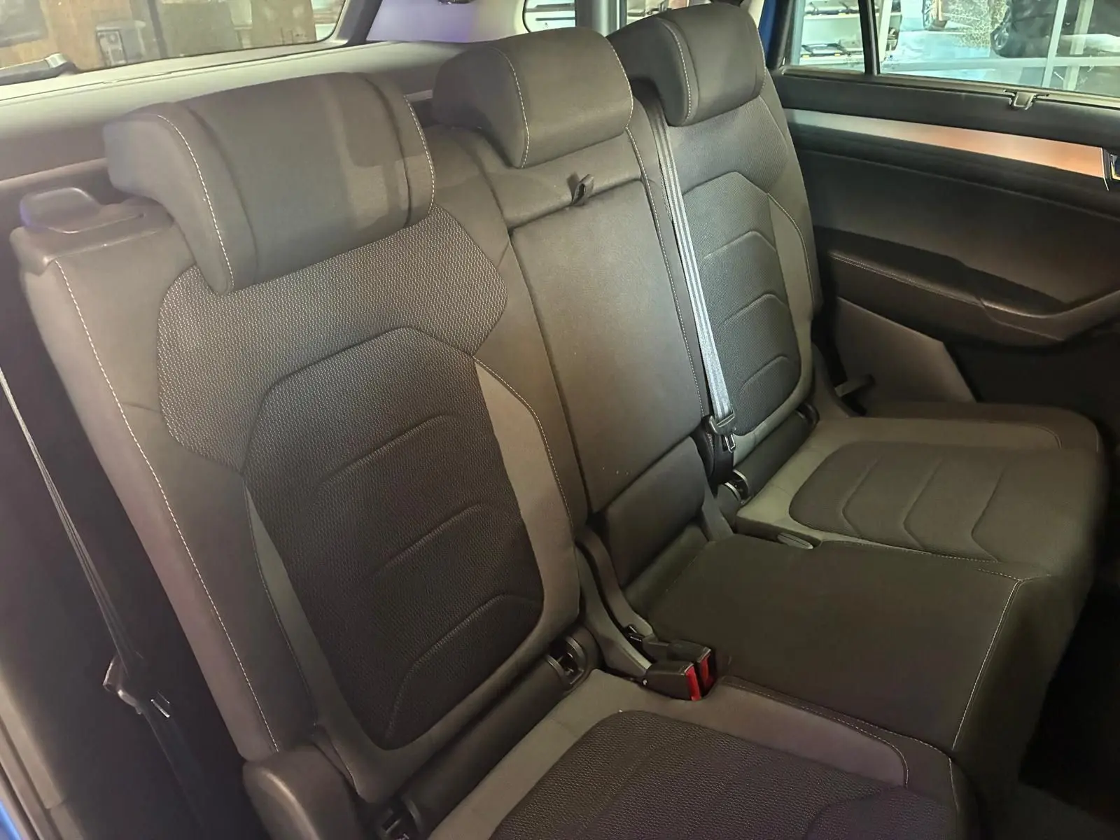Vue intérieure des sièges arrière en tissu noir du Skoda Kodiaq 2023, version 7 places, avec ceintures visibles.