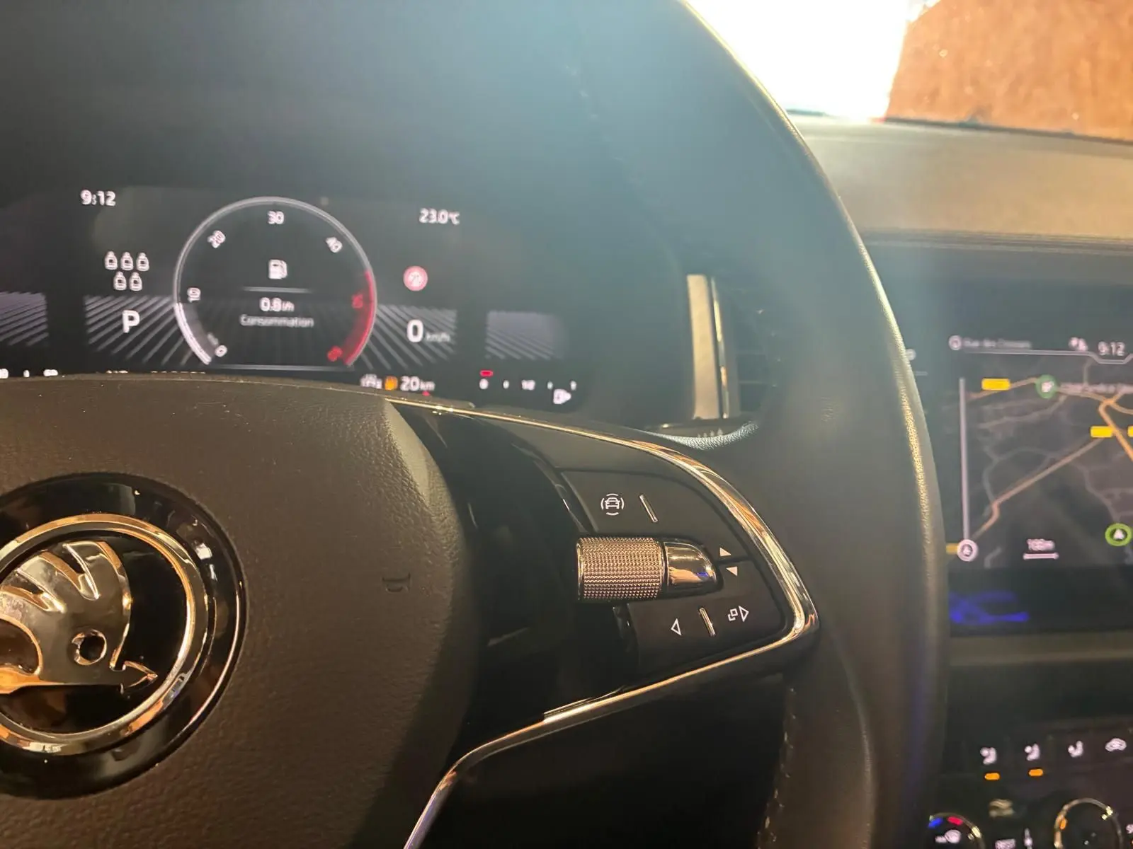 Vue rapprochée du volant noir d’un Skoda Kodiaq 2023 avec affichage numérique et écran GPS en arrière-plan.