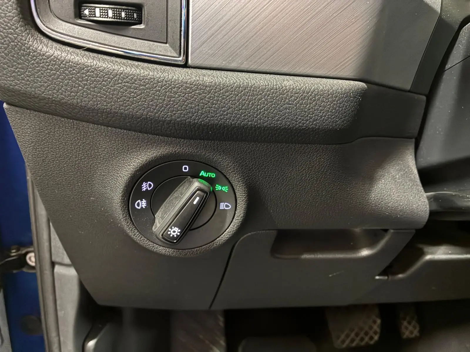 Détail du bouton de commande des phares sur le tableau de bord côté gauche d’un Skoda Kodiaq bleu 2023.