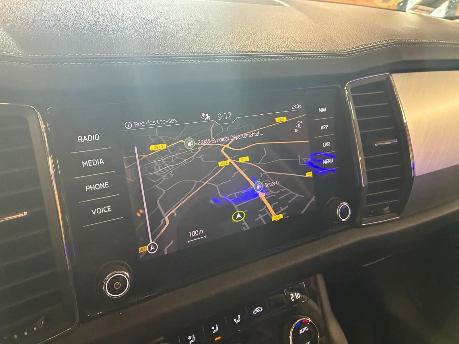 Écran tactile central du Skoda Kodiaq 2023 montrant la navigation GPS, avec commandes multimédia et climatisation visibles.