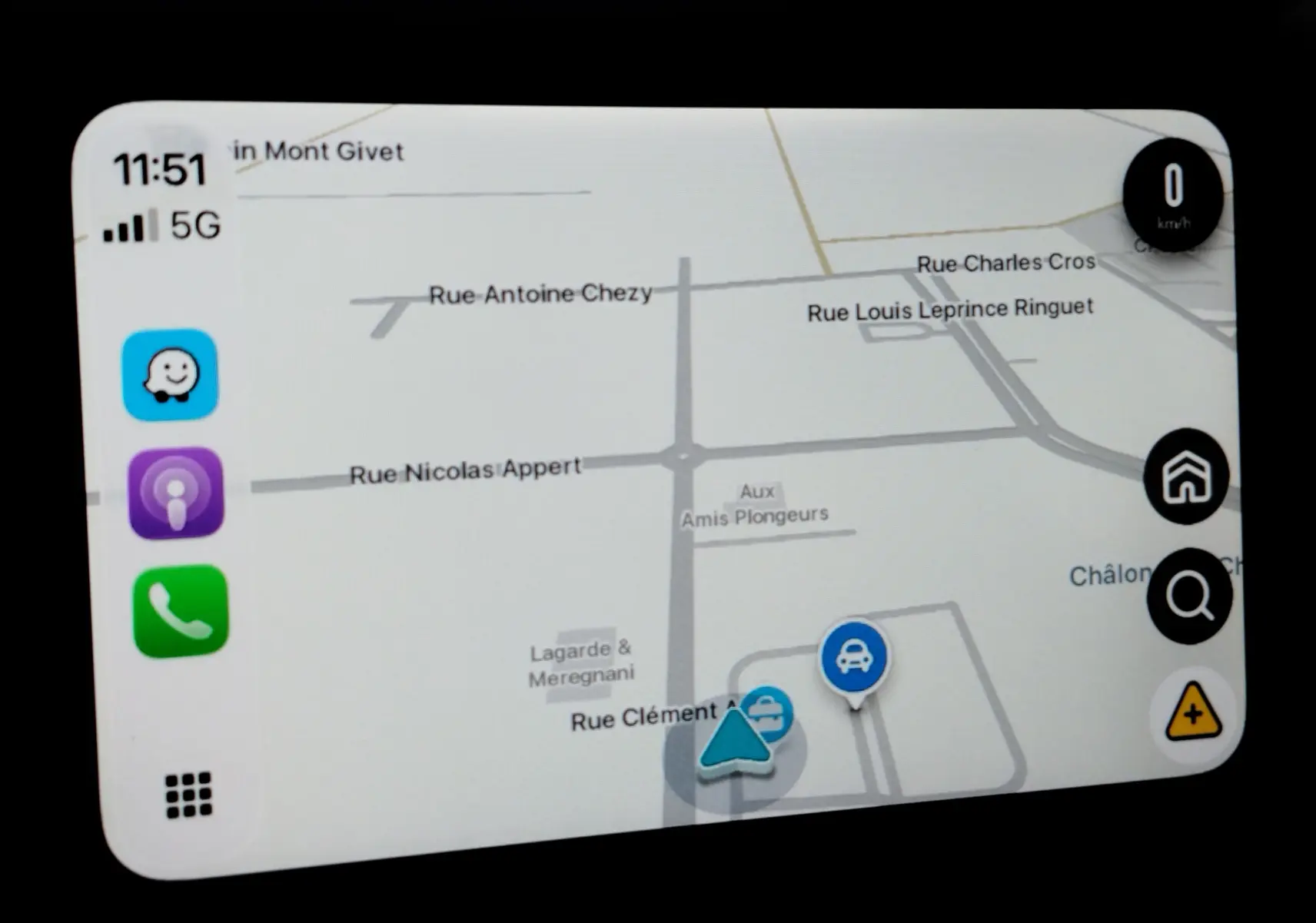 Écran de navigation du Toyota Aygo X blanc, affichant une carte avec icônes d’itinéraire et vitesse à 0 km/h.
