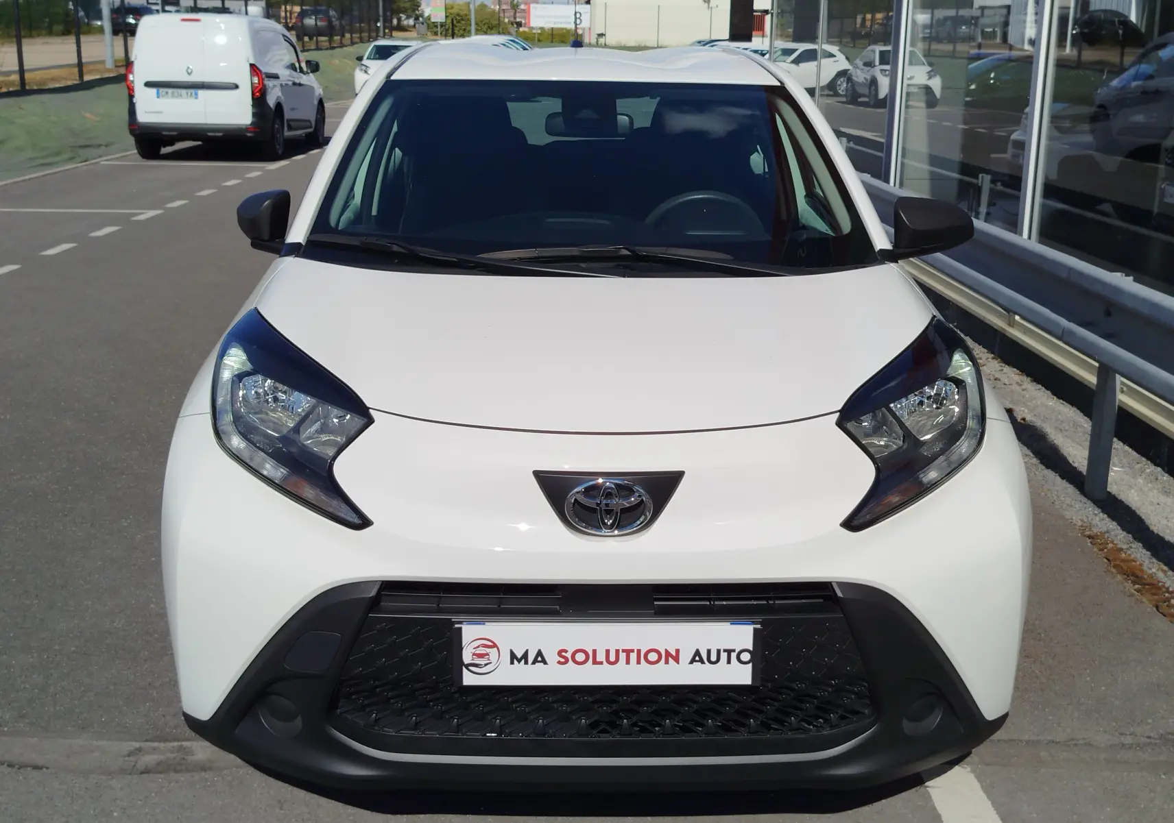 Vue de face de la Toyota Aygo X blanche, mettant en valeur ses phares anguleux et sa calandre noire distinctive.