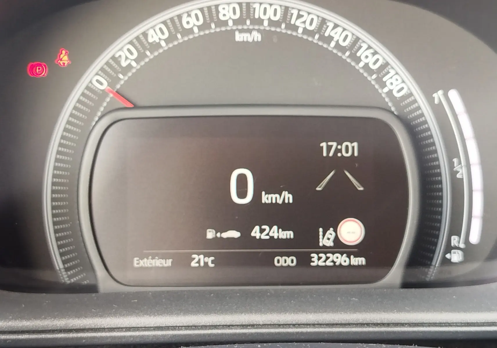 Tableau de bord numérique de Toyota Aygo X blanc, affichant vitesse à 0 km/h et autonomie de 424 km.