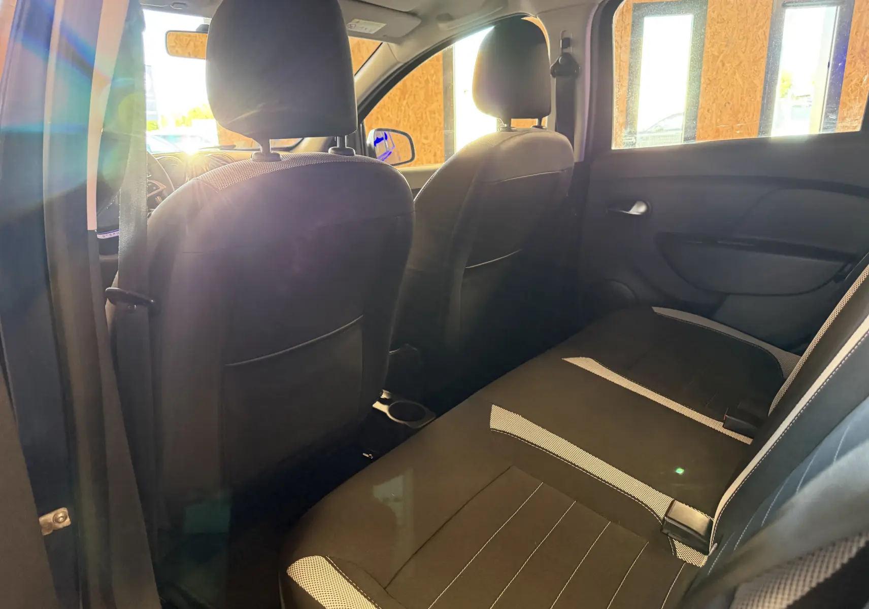 Vue intérieure arrière de la Dacia Sandero Stepway 2019, montrant les sièges noirs avec inserts gris.