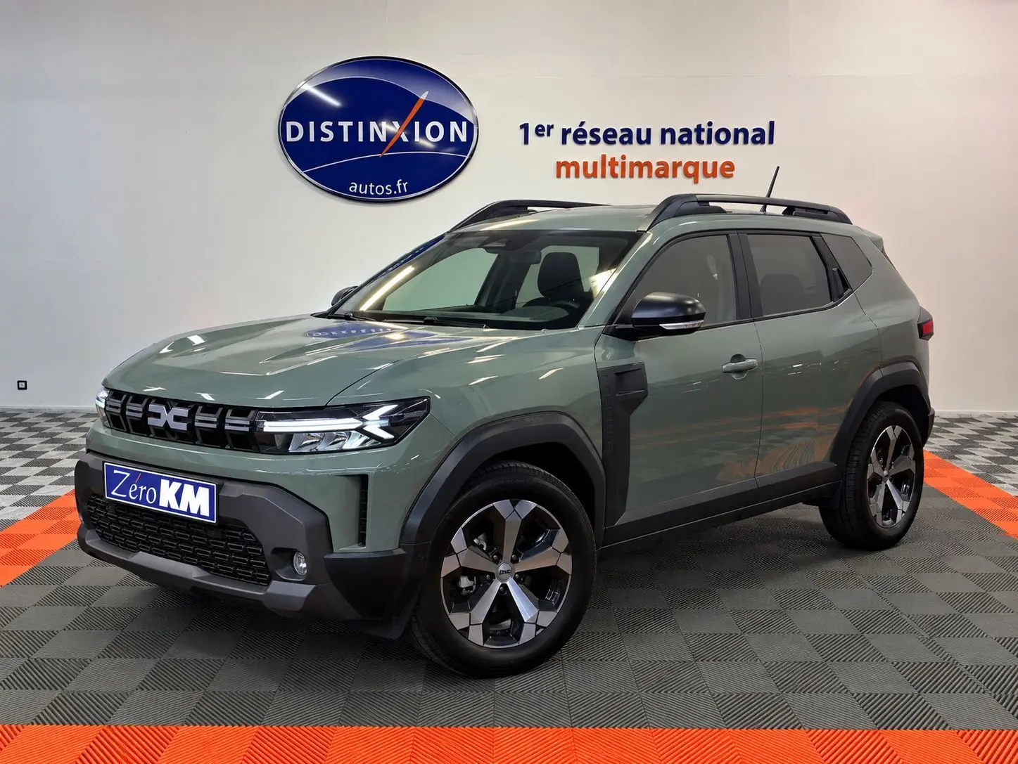 Dacia Duster 2026 vert cèdre en 3/4 avant, avec jantes alliage et détails noirs contrastants.