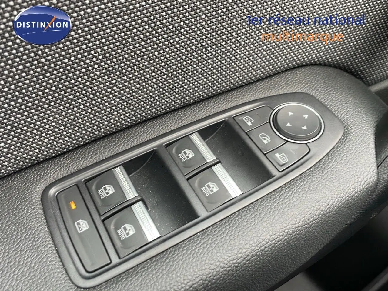 Gros plan sur les commandes de lève-vitres et rétroviseurs sur la porte côté gauche d'un Renault Captur gris rafale 2025.