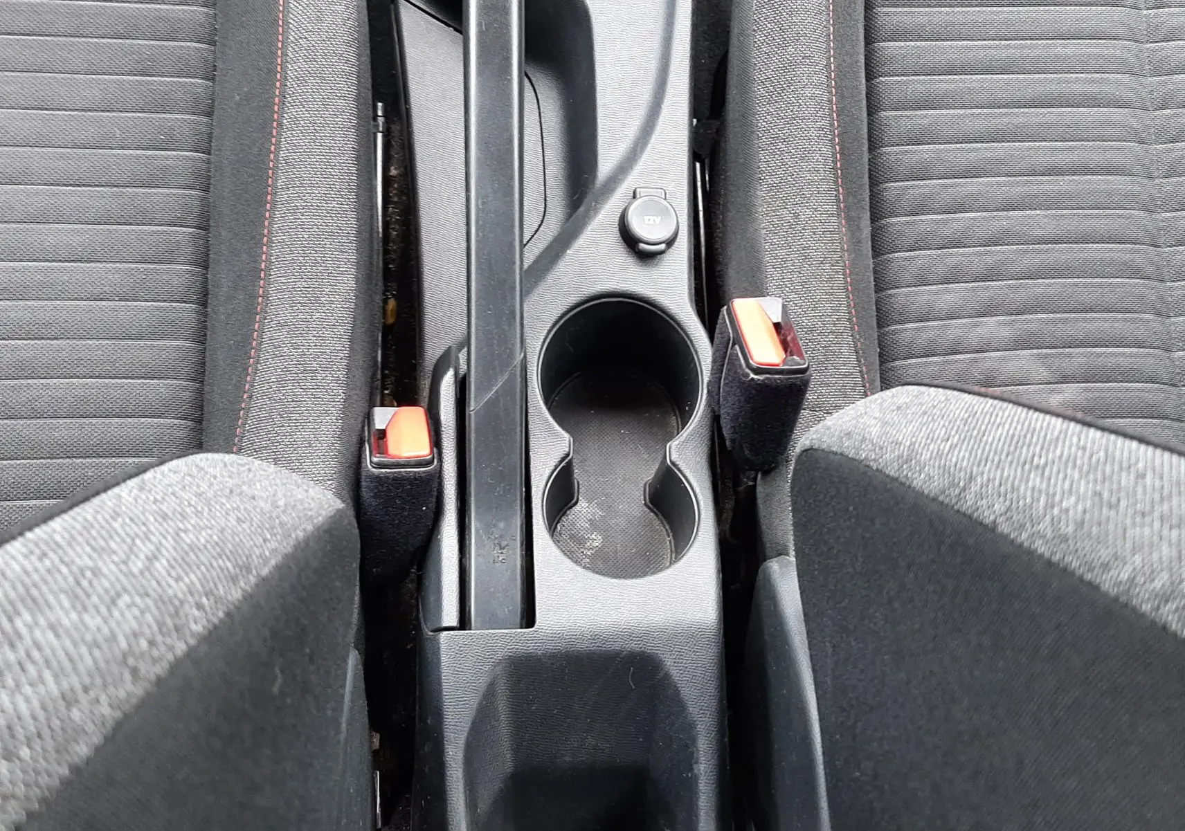 Vue plongeante sur la console centrale noire du Peugeot 2008 2020, avec frein à main manuel et sièges tissu gris.