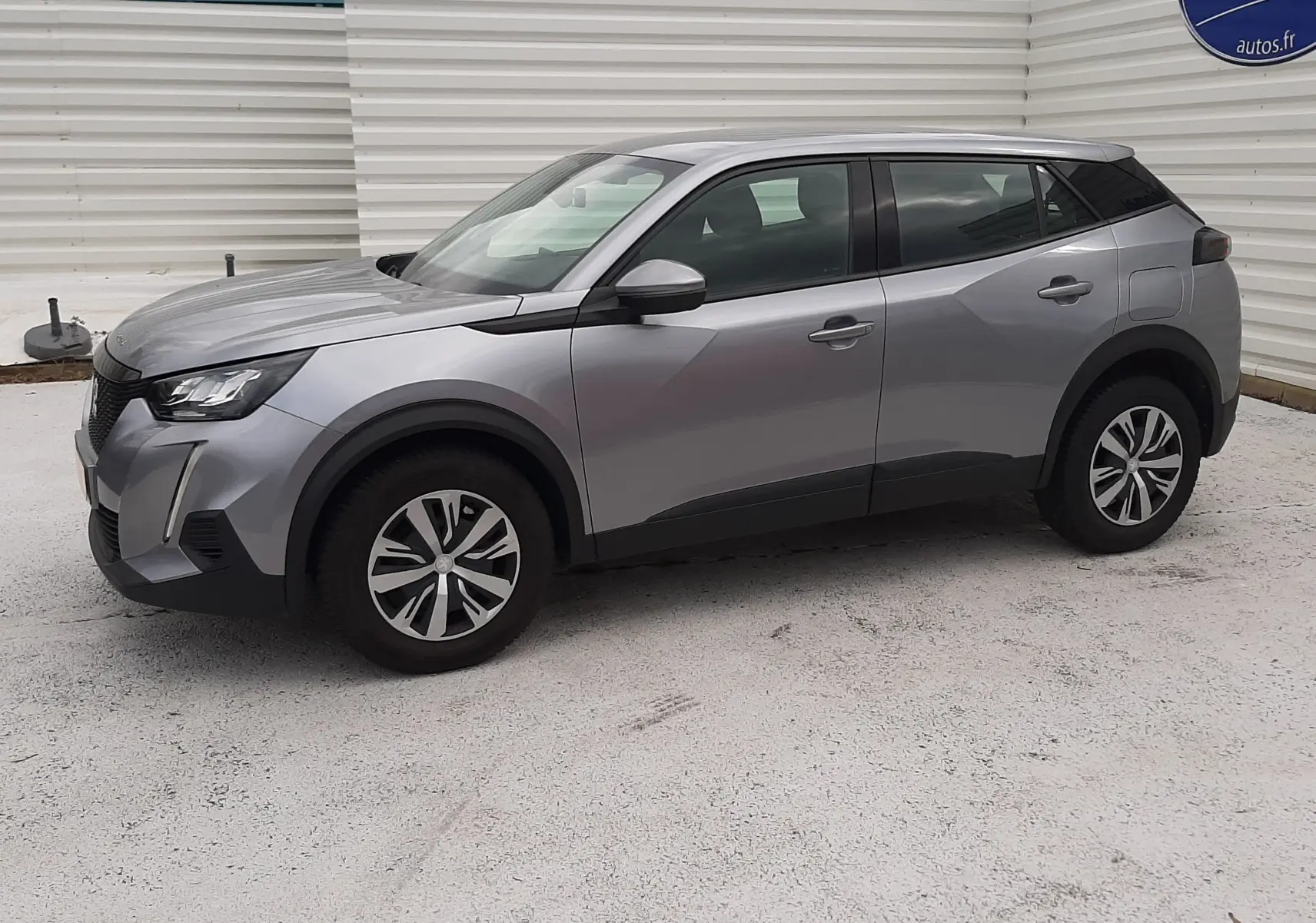 Peugeot 2008 gris Artense vue de profil côté gauche, SUV compact avec jantes alliage et lignes modernes.