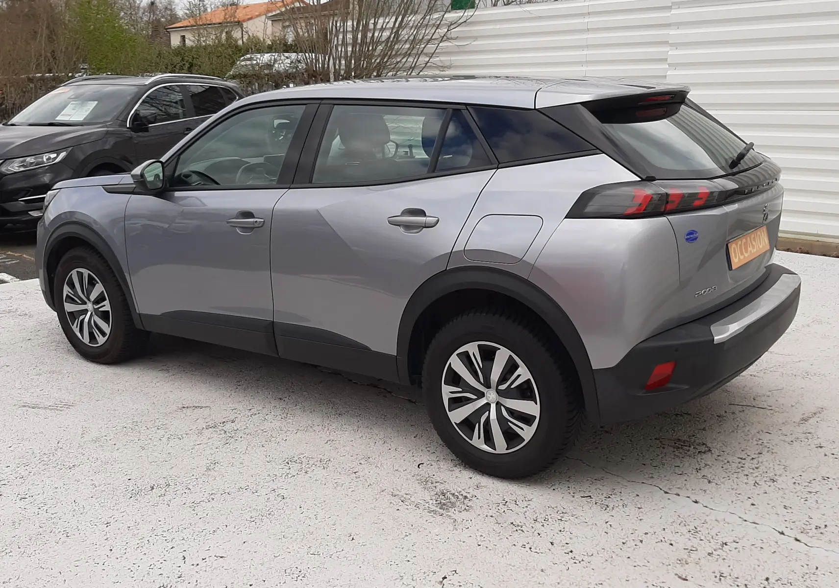 Peugeot 2008 gris Artense vue 3/4 arrière droit, avec feux arrière LED et jantes alliage distinctives.