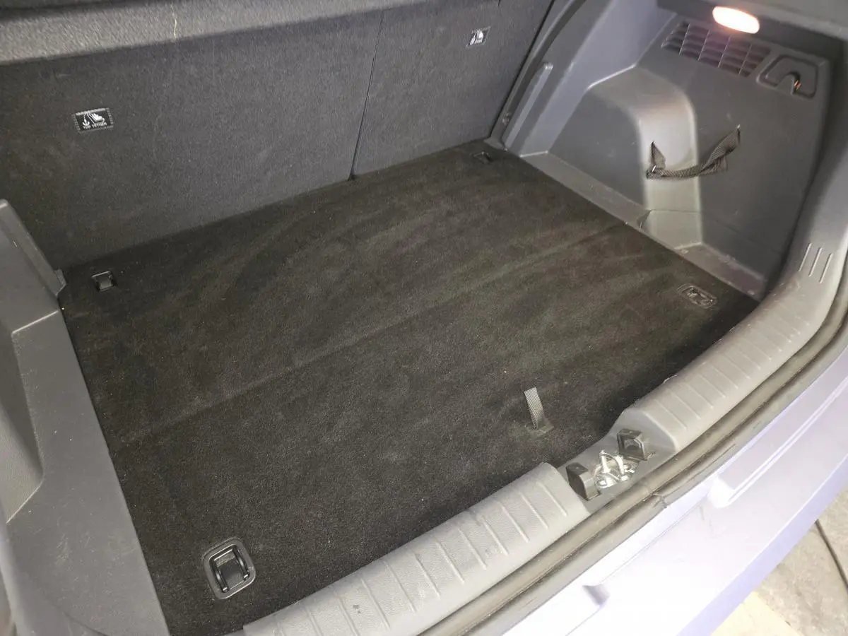 Coffre ouvert vu de dessus du Hyundai Bayon gris, montrant le plancher plat et les fixations de chargement.