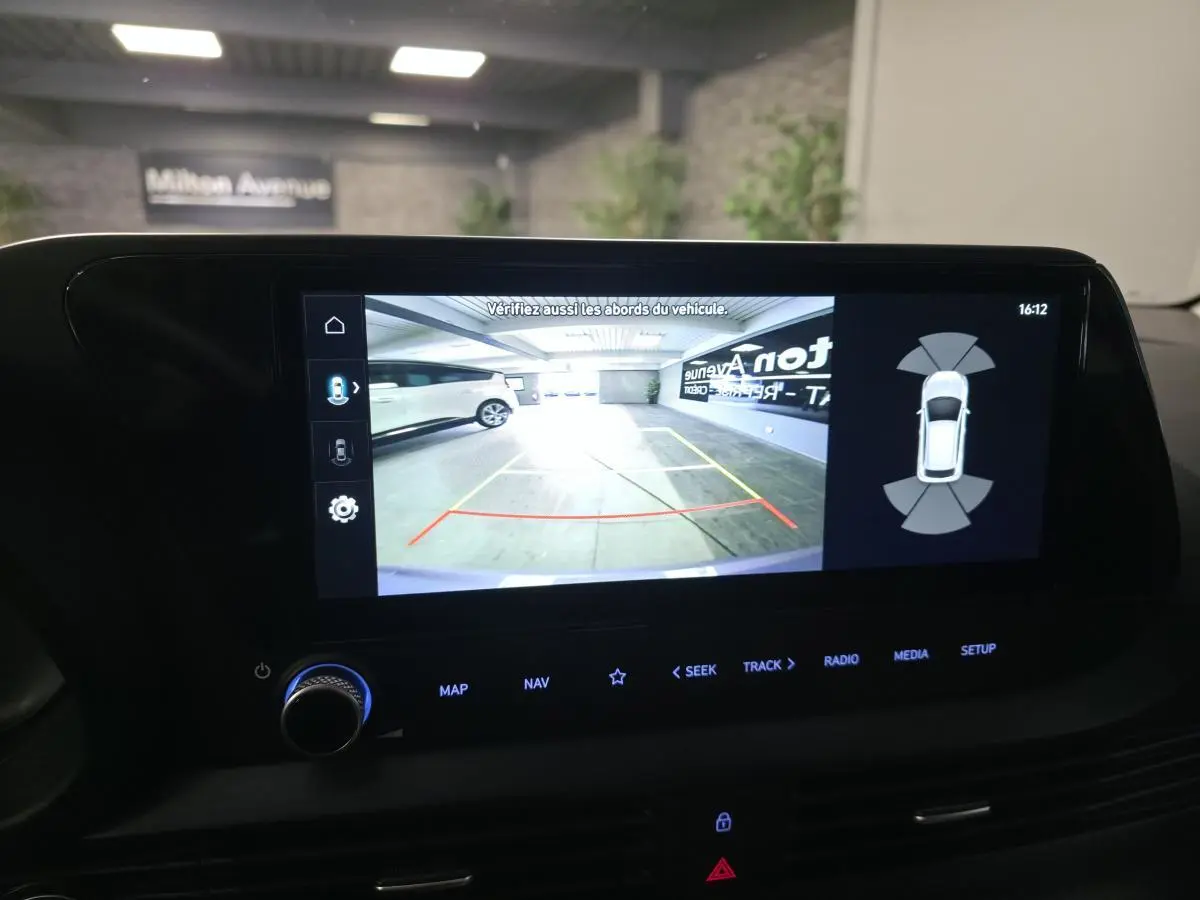 Écran tactile intérieur montrant la caméra de recul du Hyundai Bayon gris dans un parking couvert.
