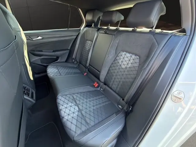 Vue latérale droite de l'intérieur arrière de la Volkswagen Golf 2.0 TDI 150 DSG R-Line avec sièges sport en cuir et tissu noir.