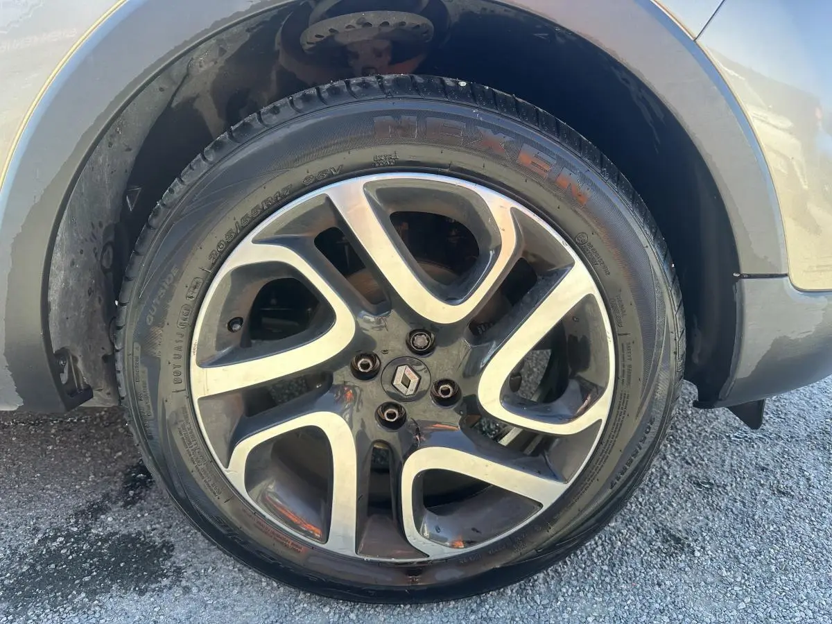 Gros plan sur la roue avant gauche du Renault Captur beige, jante alliage noir diamanté 17 pouces.