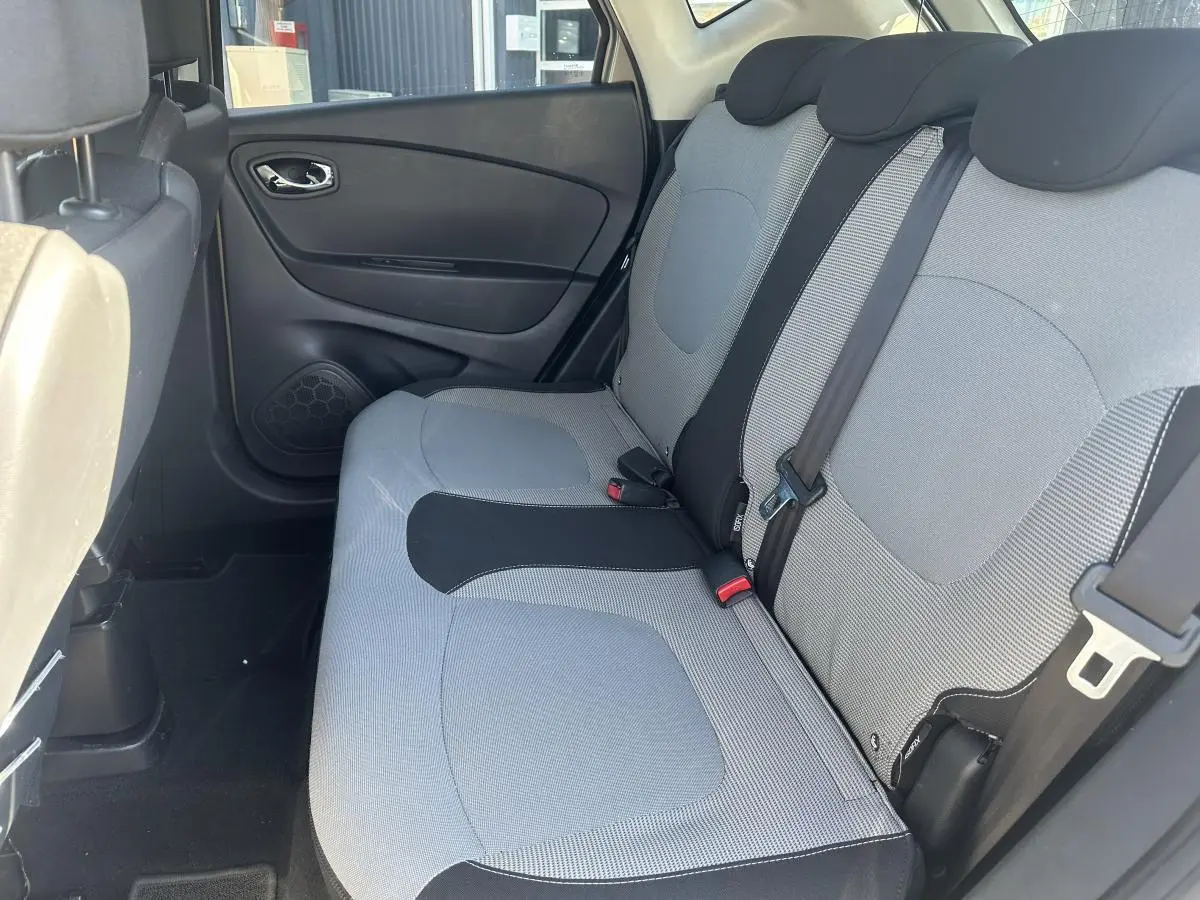Vue intérieure côté gauche sur la banquette arrière grise et noire du Renault Captur 2014 beige.