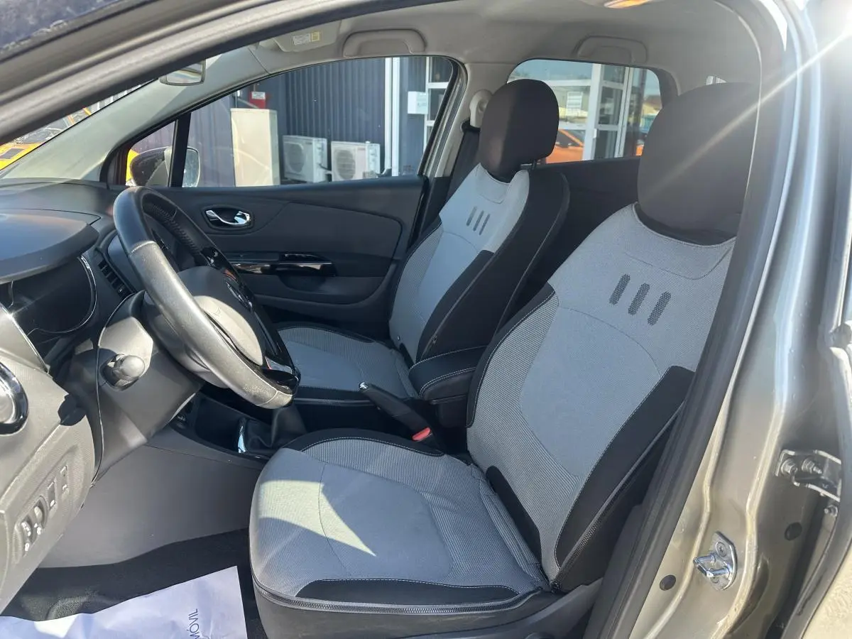 Vue intérieure côté conducteur du Renault Captur beige 2014, mettant en valeur les sièges déhoussables gris et noirs.