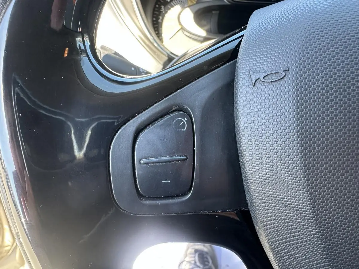 Gros plan sur le volant noir et ses commandes intégrées du Renault Captur beige, version Intens 2014.