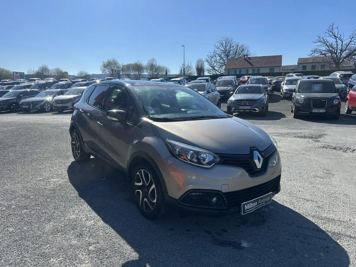 Renault Captur beige métallisé en 3/4 avant droit, avec jantes alliage noires et toit bi-ton noir.