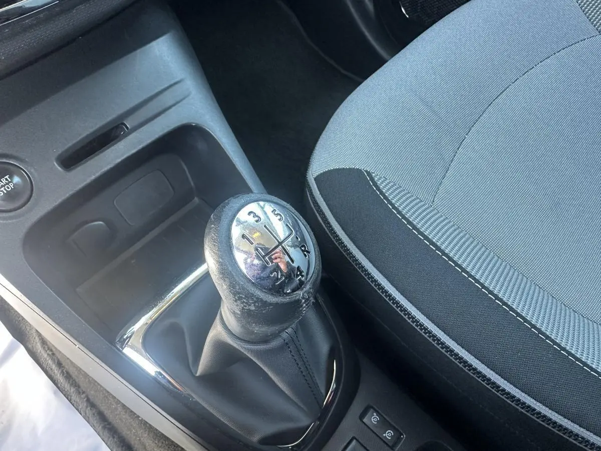 Gros plan sur le levier de vitesses manuel et la sellerie tissu gris et noir du Renault Captur beige 2014.