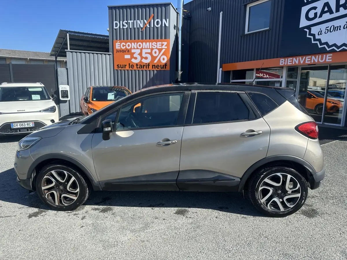 Vue latérale droite d'un Renault Captur beige métallisé avec toit noir et jantes alliage noires diamantées.