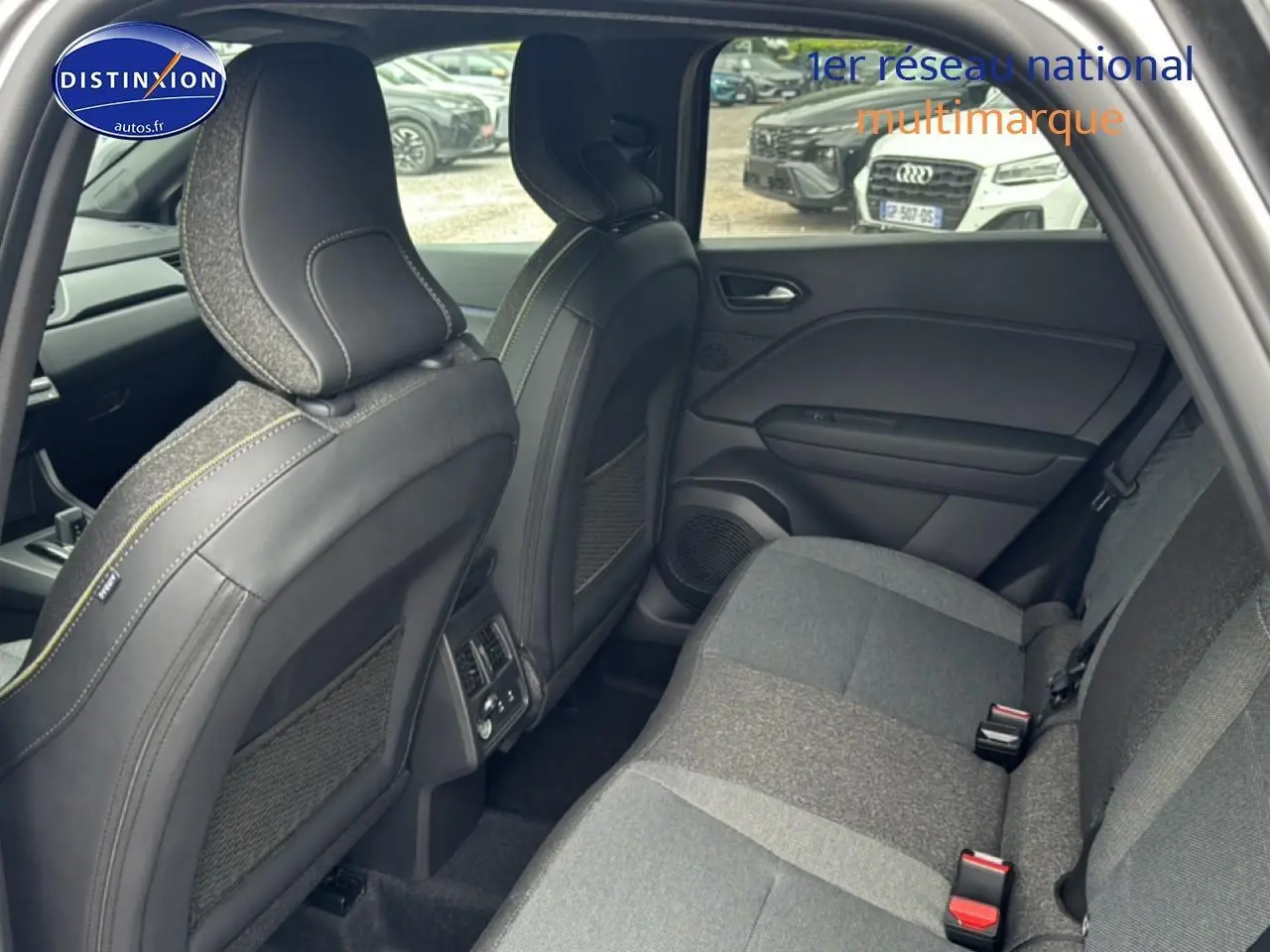 Vue intérieure arrière côté droit du Renault Captur gris cassiopée, montrant les sièges arrière et les dossiers avant en tissu et cuir.