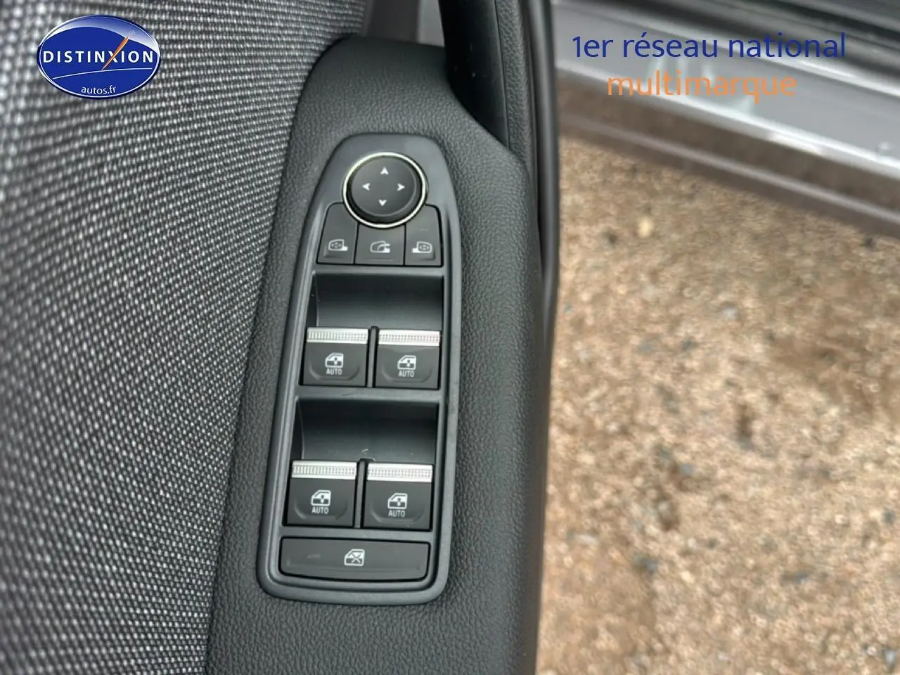 Gros plan sur les commandes des vitres électriques côté conducteur du Renault Captur gris cassiopée 2026.