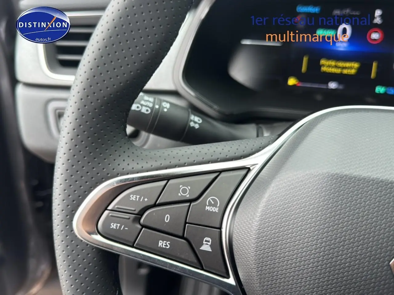 Gros plan sur les commandes multifonctions côté gauche du volant perforé d’un Renault Captur gris cassiopée 2026.