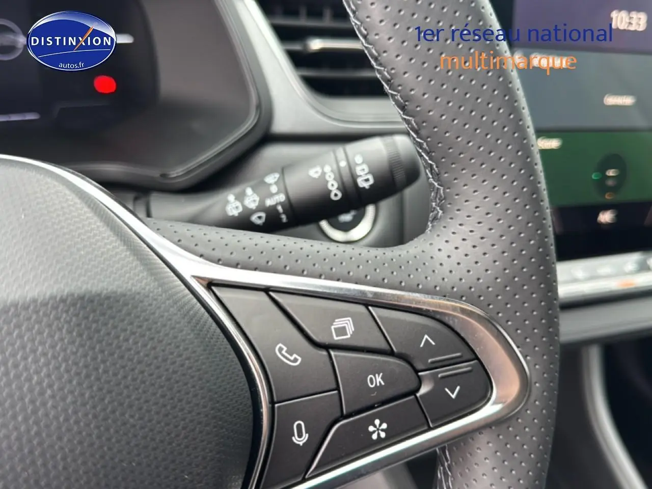 Gros plan sur les commandes au volant côté droit du Renault Captur gris cassiopée, avec tableau de bord en arrière-plan flou.