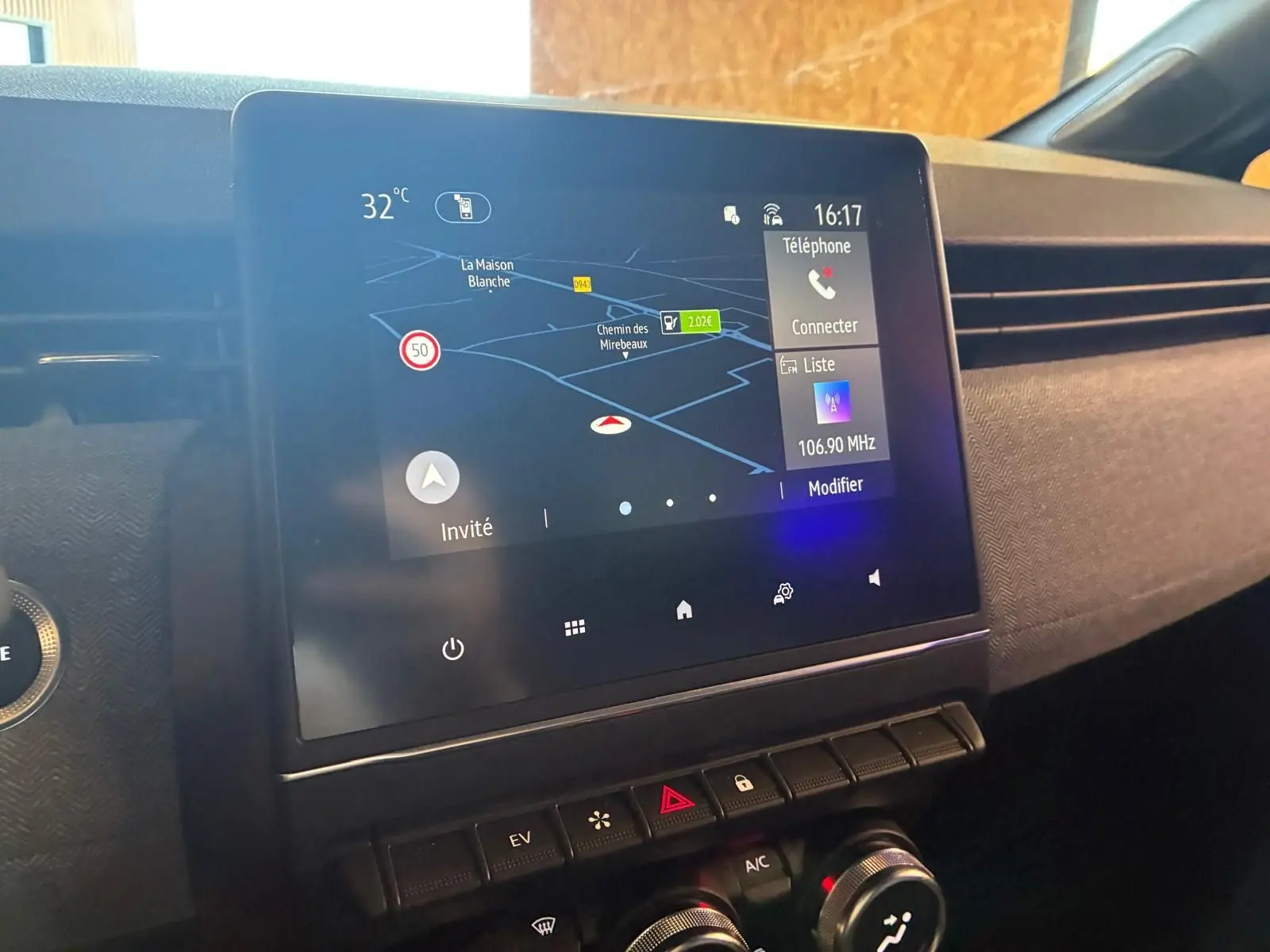 Écran tactile central avec navigation et commandes climatisation dans l'habitacle gris-noir d'une Renault Clio hybride 2025.