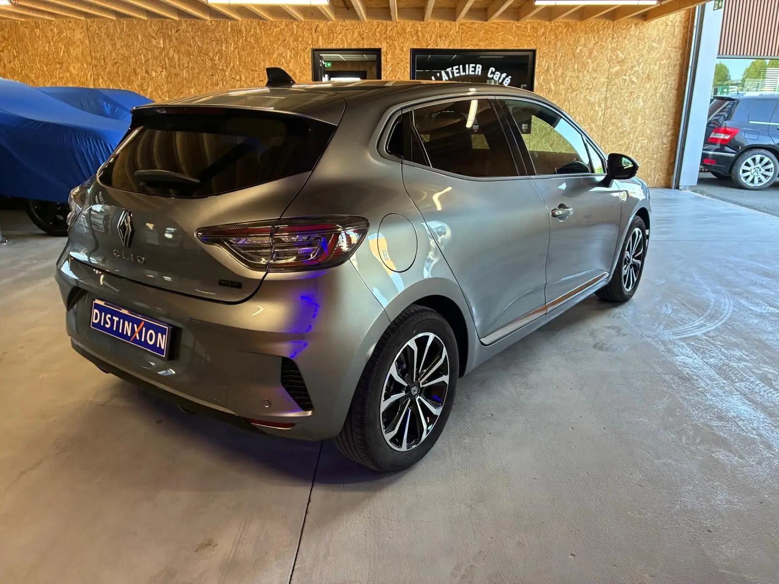 Vue 3/4 arrière droite d'une Renault Clio gris schiste 2025 avec feux LED et jantes alliage noires et argentées.