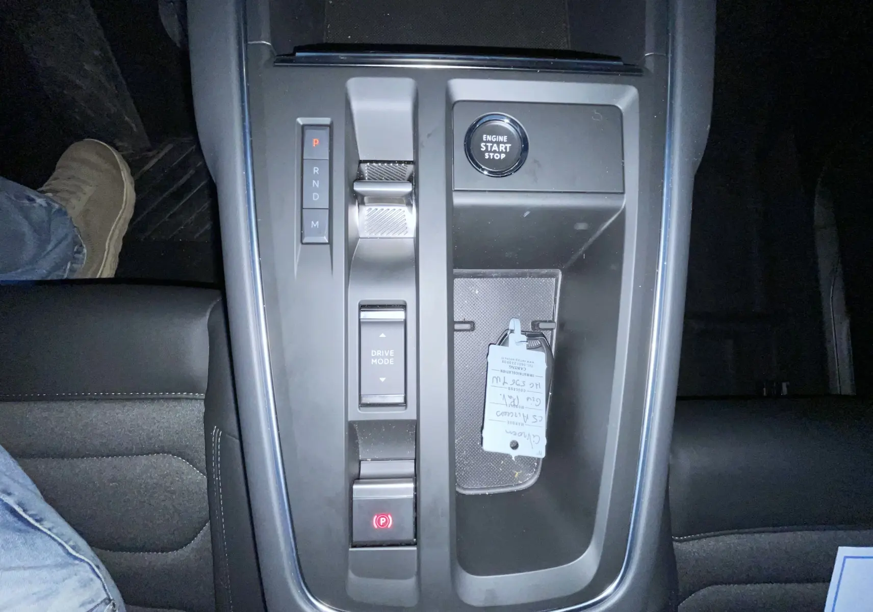 Vue plongeante sur la console centrale noire du Citroën C5 Aircross hybride 2025 avec bouton start/stop et sélecteur de vitesse.