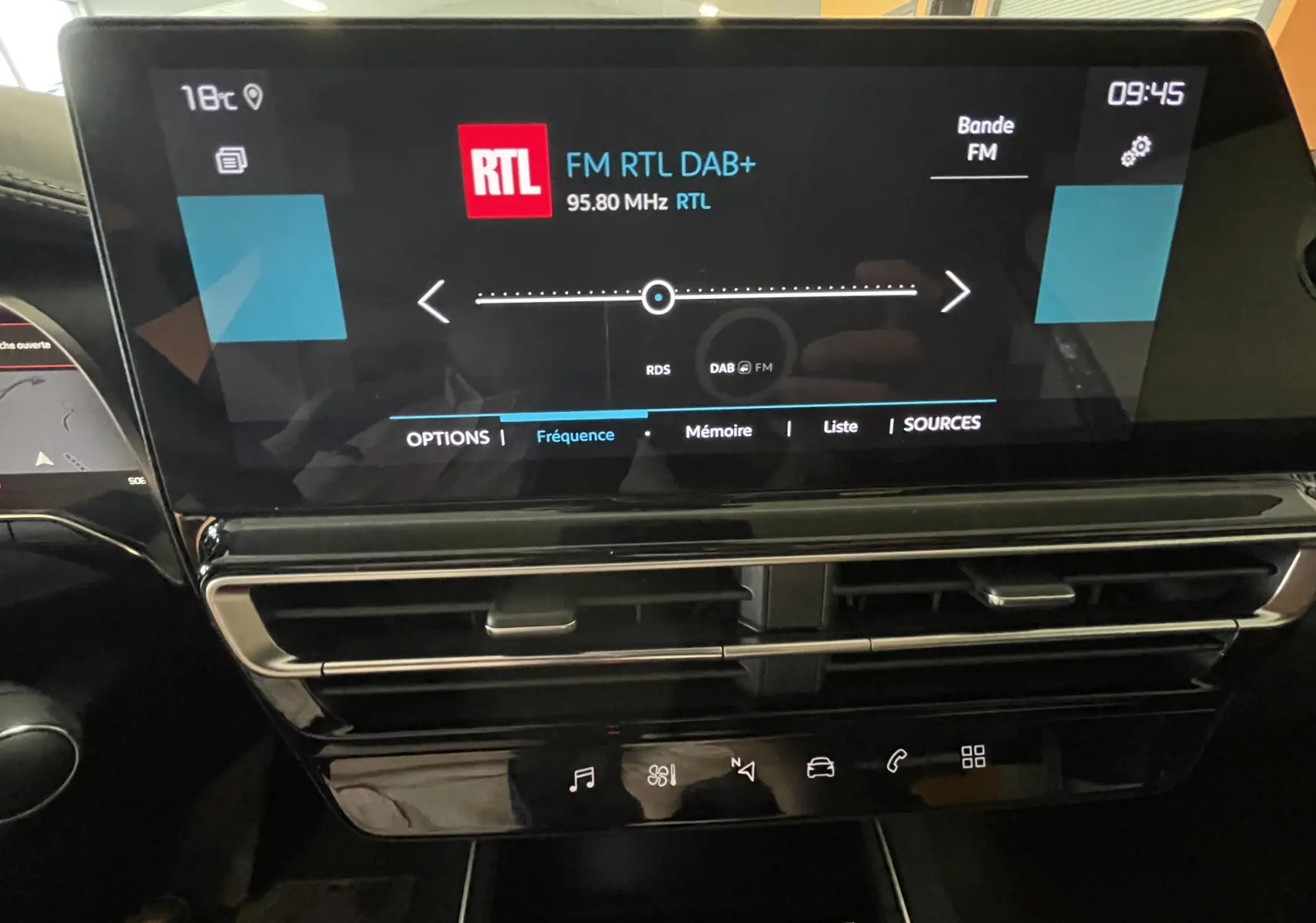 Écran tactile central du tableau de bord du Citroën C5 Aircross hybride blanc, affichant la radio RTL en intérieur.