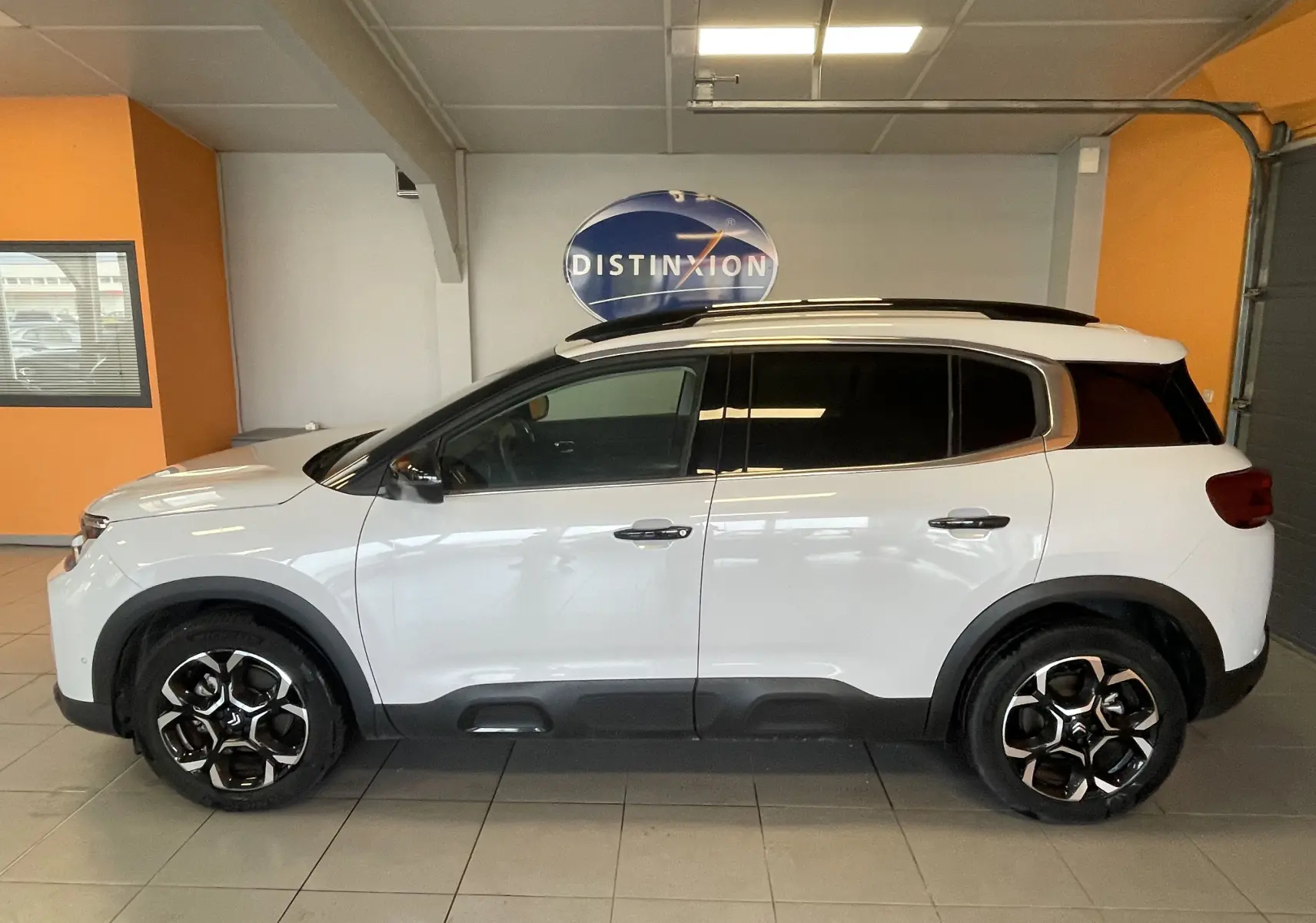 Vue de profil côté gauche du Citroën C5 Aircross hybride blanc Okenite avec jantes alliage 18 pouces biton et vitres arrière surteintées.