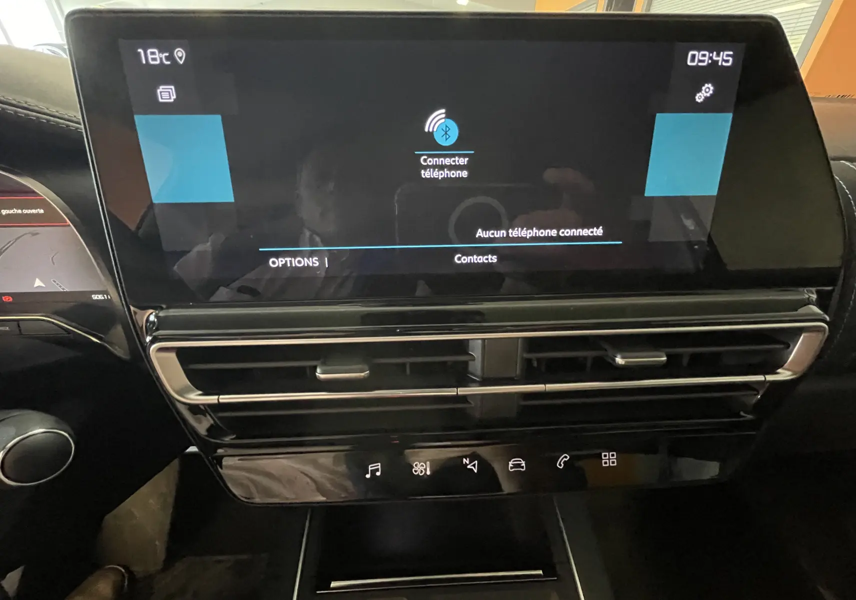 Écran tactile central noir du tableau de bord du Citroën C5 Aircross hybride 2025 avec commandes climatisation et connectivité Bluetooth.