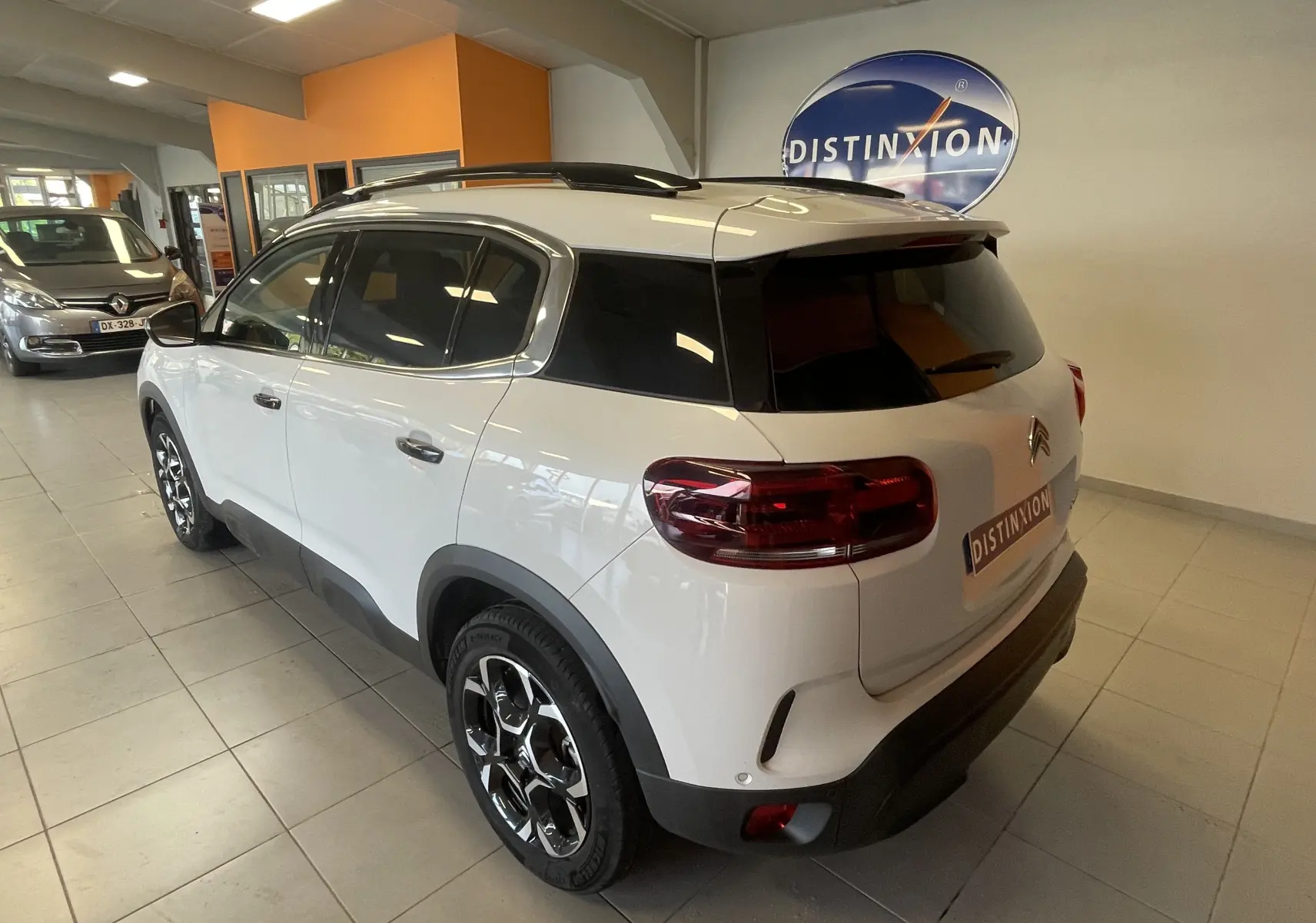 Vue 3/4 arrière droite du Citroën C5 Aircross hybride blanc Okenite avec jantes alliage 18 pouces biton et vitres arrière surteintées.