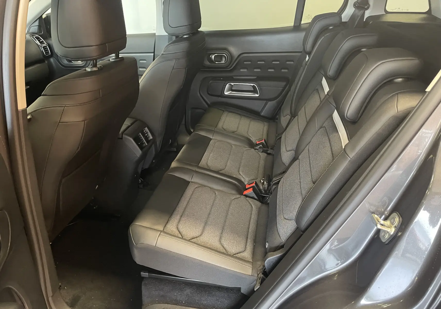 Vue intérieure côté droit des sièges arrière en tissu et cuir du Citroën C5 Aircross hybride 2025 avec porte ouverte.