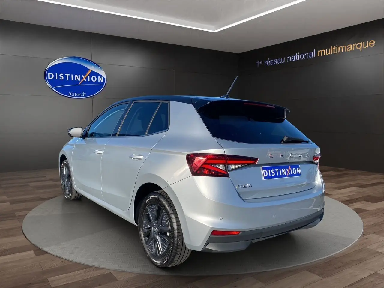 Vue 3/4 arrière droite d'une Skoda Fabia 2024 gris clair avec toit noir et jantes distinctives en concession.