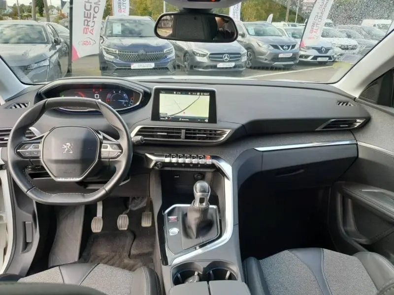 Vue intérieure avant du Peugeot 3008 blanc nacré 2017, tableau de bord moderne avec écran tactile et volant multifonction cuir.