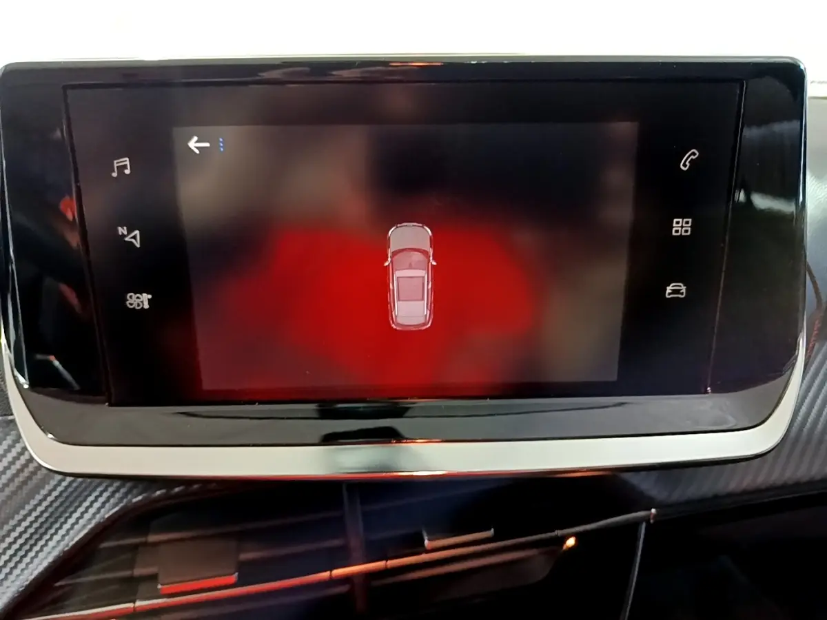 Écran tactile central affichant la vue de dessus du véhicule en mode stationnement dans un Peugeot 2008 gris clair.