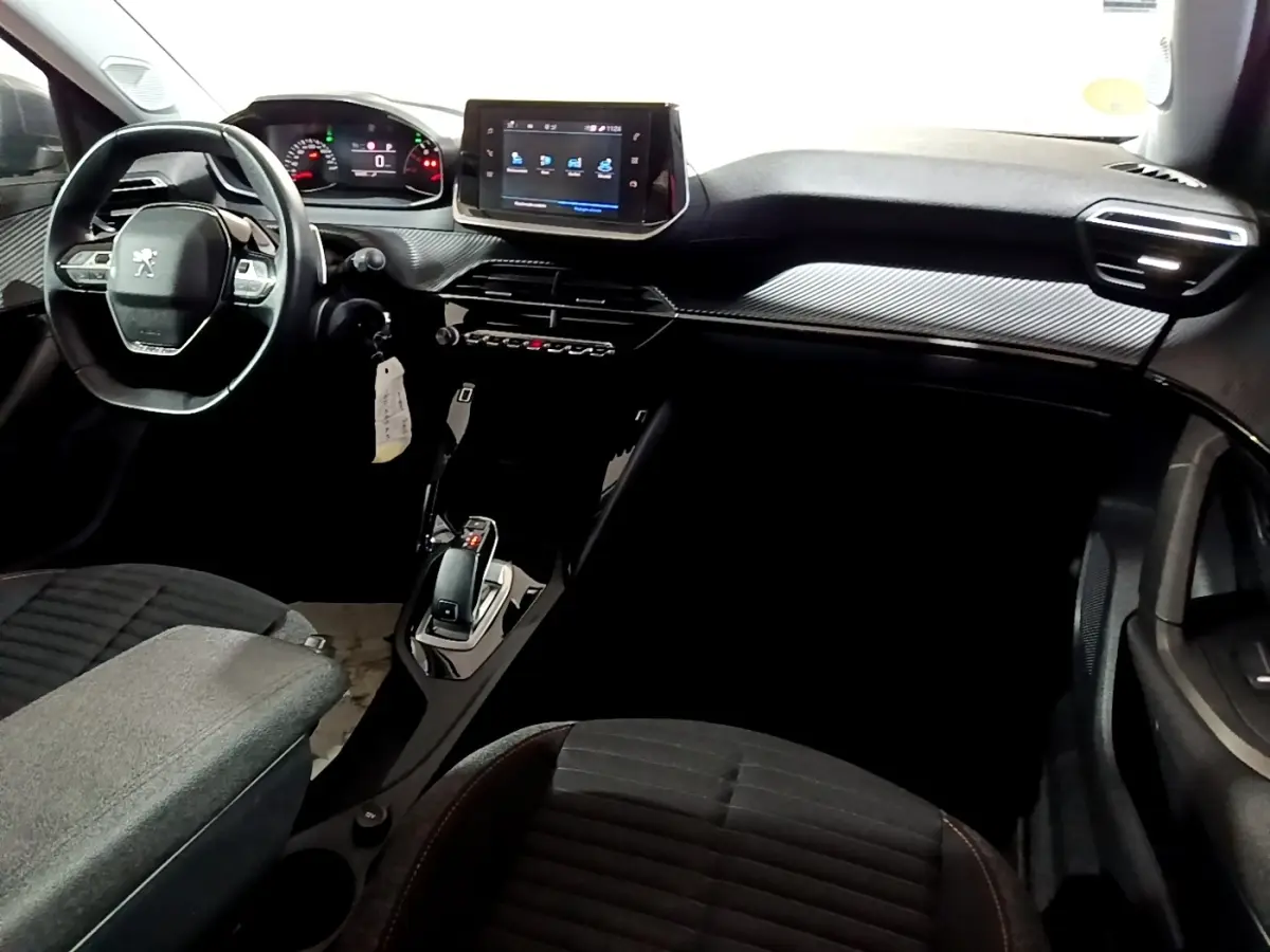 Vue intérieure côté conducteur du Peugeot 2008 gris clair, mettant en valeur le volant cuir multifonctions et l’écran tactile central.