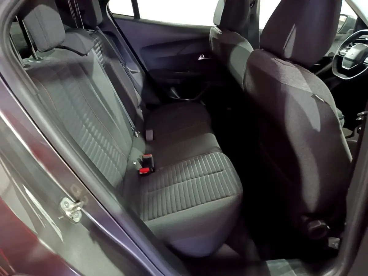 Vue intérieure côté gauche sur la banquette arrière noire du Peugeot 2008 gris clair, avec sièges tissu et ceintures visibles.