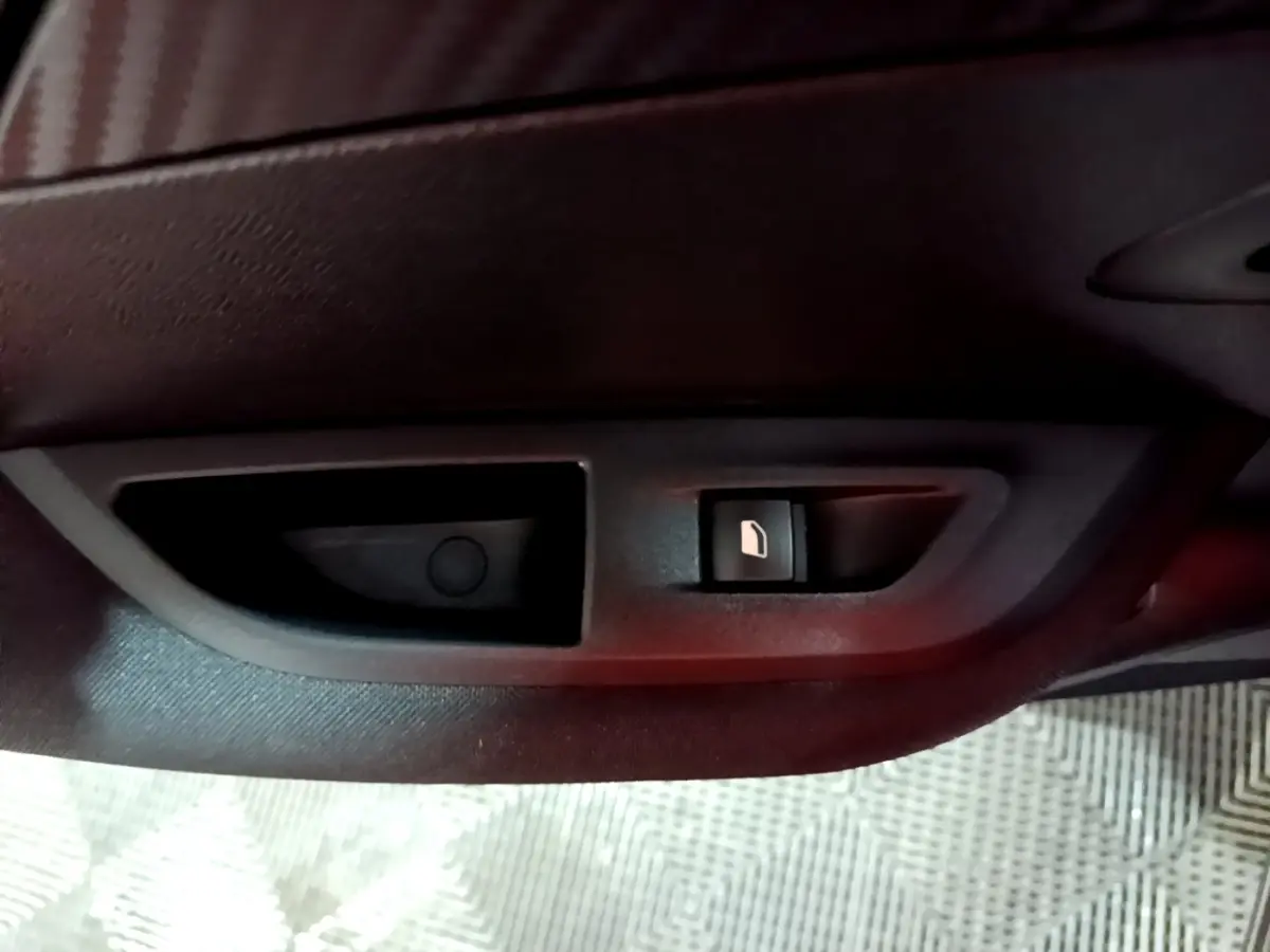 Gros plan sur la commande de verrouillage des portes côté intérieur d'une Peugeot 2008 gris clair, version Active Business.