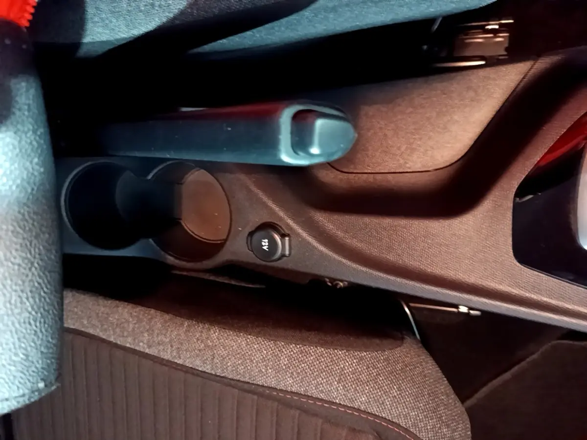 Gros plan sur le frein à main et prise 12V au centre de l’habitacle du Peugeot 2008 gris clair, version 2021.